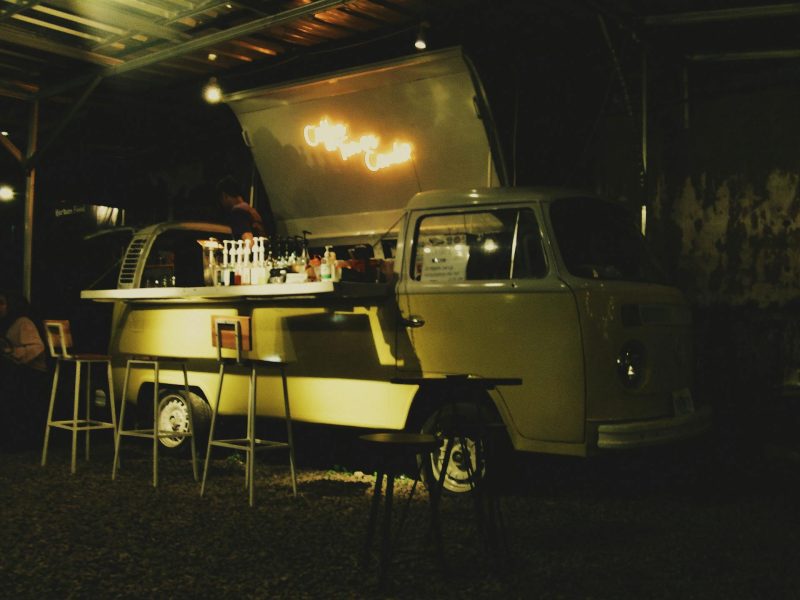 Mobilus baras vestuvių šventėje, svečiai mėgaujasi kokteiliais ir bendrauja lauke